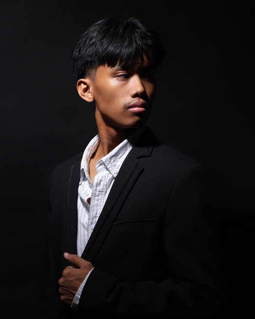 Jude Rodriguez in a dark studio portrait.